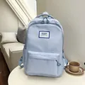 Light blue minimalist nylon backpack with front pocket on a white table - Blue