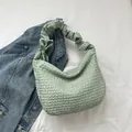 Sac hobo vert clair plissé minimaliste présenté sur un fond de veste en jean bleu - Vert