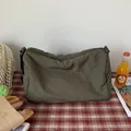 Bolso bandolera grande de lona verde militar para mujer sobre una alfombra de picnic - Verde oliva
