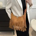 Bohemian brown suede shoulder bag with layered tassels and knotted strap on model - Tan