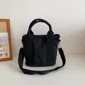 Bolso tote clásico de lona negra con correa ajustable y diseño minimalista - Negro