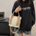 Versatile borsa tote in tela beige con tracolla kaki indossata come borsa a tracolla - Bianco