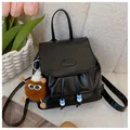 Chic black PU leather mini backpack with drawstring and plush charm on white texture - With Pendant-Brown / Black