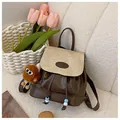 Fashionable brown and beige patchwork backpack with a cute plush monster keychain - White & Coffee