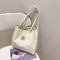 Cream white corduroy tote bag with feather patch and metallic ring handles for women - Off White