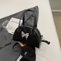 Minimalist black bowling handbag in suede and leather with silver butterfly accent - Black