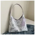 White tote bag with purple butterfly print and matching coin purse on denim background - Purple