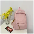 Minimalistische lichtroze nylon rugzak voor studenten met modelabel op een witte tafel - 28*12*40cm / Roze