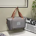 Grey large capacity travel bag with pink straps shown hanging in a home setting - Pinkish Grey