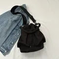 Minimalistische schwarze Beuteltasche mit Tunnelzug, Falten-Design und breitem Gurt - Schwarz
