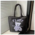 Quilted black puffer tote bag with purple teddy bear graphic and baby girl text - Black