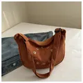 Brown corduroy shoulder bag featuring white circular embroidery and adjustable strap - Brown