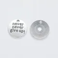 Detailed macro view of vintage silver alloy charms showing 'never give up' engraving and texture - Antique Silver