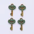 Detailed view of four vintage heart-shaped crown key pendants in bronze and teal - Antique Green