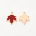 Macro detail of red enamel maple leaf pendant with golden metal back and loop - Burgundy