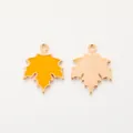 Detailed view of gold alloy maple leaf pendants with yellow enamel finish and textured back - Turmeric