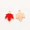 Detailed macro view showing both front red enamel and textured gold back of maple leaf charms - Red