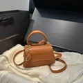 Mini-Handtasche aus karamellfarbenem Leder mit Lychee-Muster und Goldbeschlägen - Braun