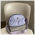 Light purple nylon crossbody bag with pleated front pocket and wide fabric shoulder strap - Purple
