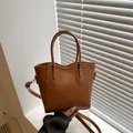 Minimalist brown faux leather bucket bag with top handle and gold-tone fashion hardware - Tan