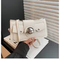 Chic beige leather shoulder bag featuring stylish dual flap pockets and a large metal ring - White