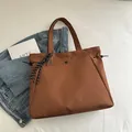 Brown canvas tote bag with tennis racket charm and woven tassel in casual style - With Pendant / Brown