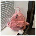 Roze corduroy mini-rugzak met zwart lachend gezicht en zachte witte pluche bal hanger - Roze