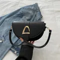Moderne schwarze Satteltasche aus Leder mit goldenem Metallverschluss und Tragegriff - Schwarz