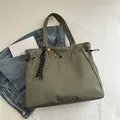 Olive green nylon tote bag for women with sporty tennis racket pendant and drawstring details - With Pendant / Green