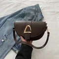 Dunkelbraune Satteltasche mit goldenem D-Ring-Verschluss und glattem Lederfinish - Braun