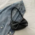Chic black Y2K shoulder bag with large bow detail and sleek faux leather finish - Black