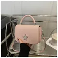 Pink faux leather crossbody bag with star emblem and diagonal striped texture - Pink