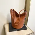 Brown lychee leather bucket bag with silver chain charm and soft shoulder strap - Brown