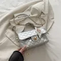 Zilveren gewatteerde crossbodytas met gouden sluiting en zijden sjaalhandvat op een blazer - Zilver