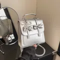 Silver metallic mini backpack with bow detail and heart pearl charm in front and back view - With Pendant / Silver