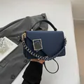 Dark blue minimalist shoulder bag with geometric clasp and woven chain strap detail - Blue