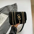 Sac bandoulière en velours noir avec motif matelassé en V et pompon doré en métal - Noir