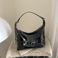 Glossy black shoulder bag with silver hardware and punk-style industrial buckle detail - Black