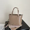 Borsa a secchiello kaki minimalista con etichetta metallica e tracolla regolabile - Kaki
