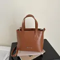 Borsa a secchiello in ecopelle marrone con targhetta FASHION in metallo e tracolla - Marrone chiaro