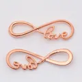 Macro detail of rose gold infinity love pendants for DIY jewelry making and crafts - Rose Gold