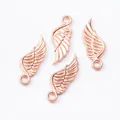 Detailed macro of rose gold zinc alloy wing charms with intricate feather textures for DIY jewelry - Rose Gold