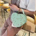 Détail du sac à main cœur vert menthe avec broderie florale et bandoulière dorée - Vert menthe