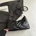 Bolso de hombro minimalista en ecopiel negra con textura grabada y detalles dorados - Negro