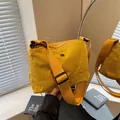 Chic mustard yellow nylon crossbody bag with wide adjustable shoulder strap and metal logo - Yellow