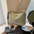 Pea green canvas crossbody bag with adjustable strap and metallic logo detail - Green