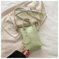Minimalistische hellgrüne Eimer-Schultertasche mit Hund-Anhänger und verstellbarem Gurt - Grün