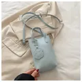 Hellblaue vertikale Beuteltasche mit kleinem Hundeanhänger und Schultergurt - Blau