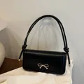 Elegante bolso bandolera negro con lazo dorado y asas con nudos decorativos - Negro