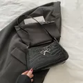 Fashionable black crocodile pattern underarm bag with a silver metal bow buckle accent - Black